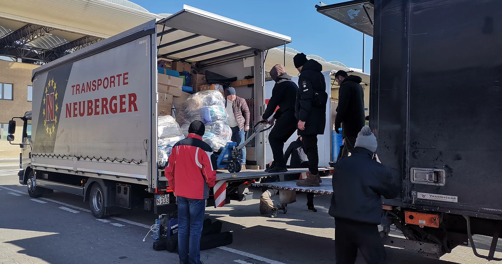 Umladen der Spenden von einem LKW in den anderen 