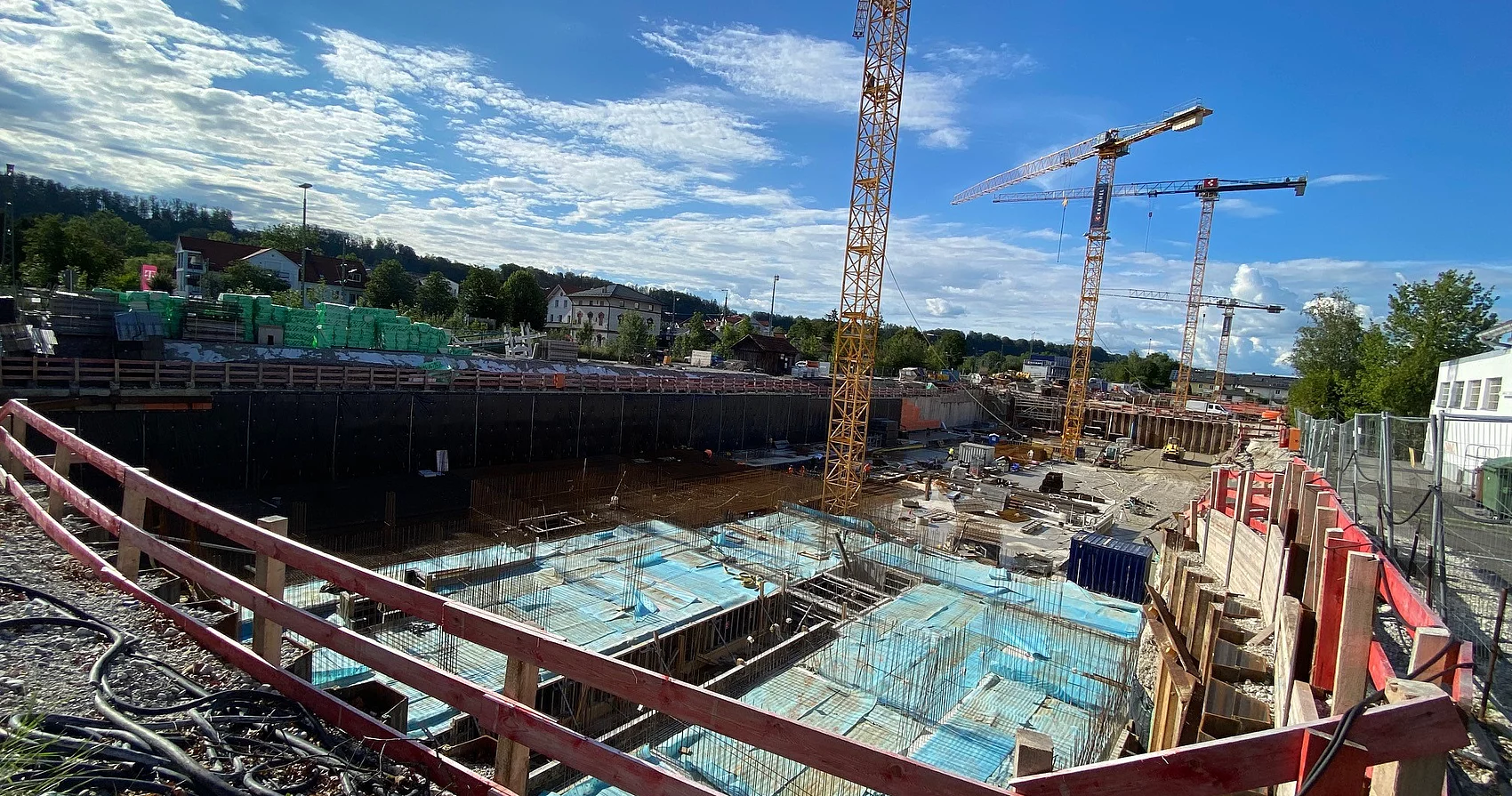 Große Baugrube mit mehreren Baukränen