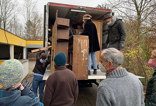 Studenten entladen Laster mit Holzelementen aus dem Geigerladen