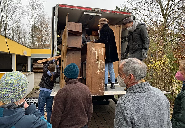 Studenten entladen Laster mit Holzelementen aus dem Geigerladen