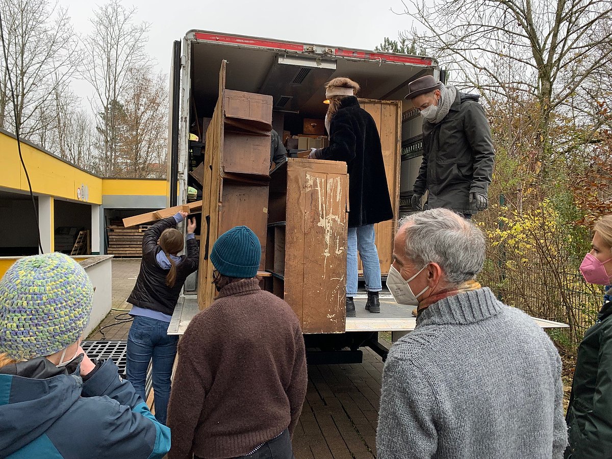 Studenten entladen Laster mit Holzelementen aus dem Geigerladen