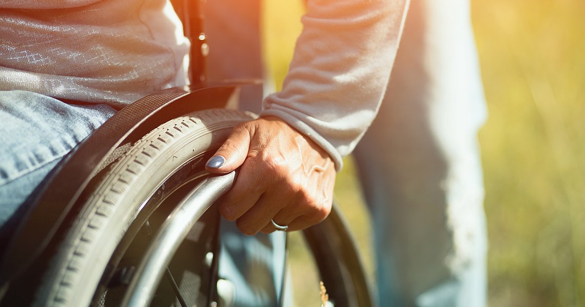 Symbolbild Hand einer Rollstuhlfahrerin