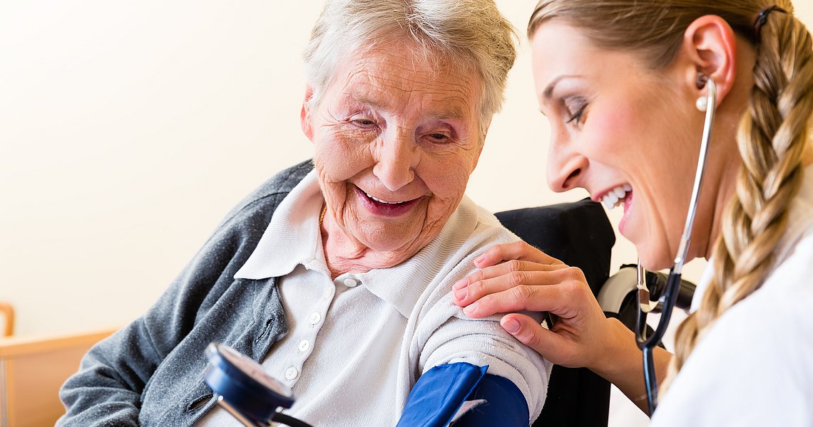 Symbolbild Krankenschwester misst Blutdruck bei älterer Patientin