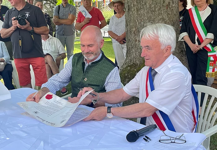 Bürgermeister André Meuraillon und Klaus Heilingelchner unterzeichnen die Urkunde zur Städtepartnerschaft