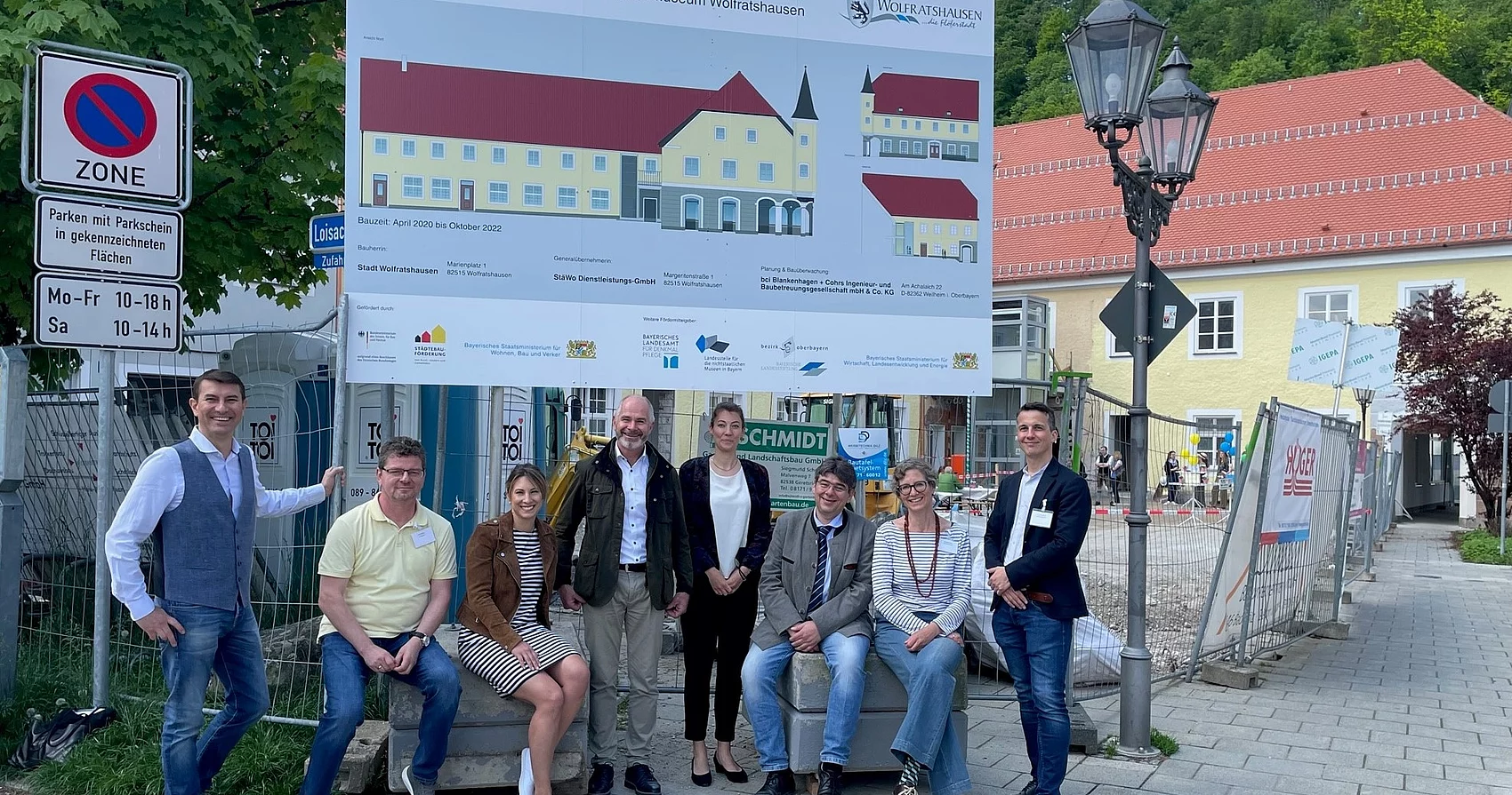 Gruppenbild mit Bürgermeister, Bau- und Referatsleitern vor Bautafel