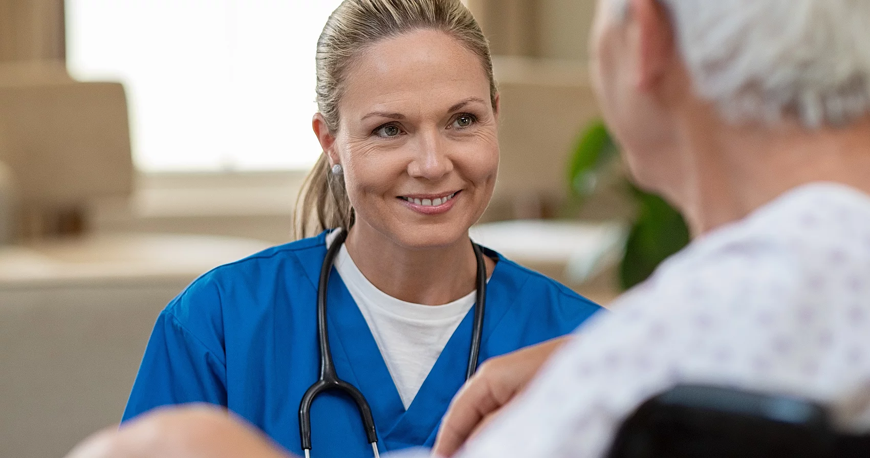 Symbolbild Beraterin spricht mit behinderter Frau 