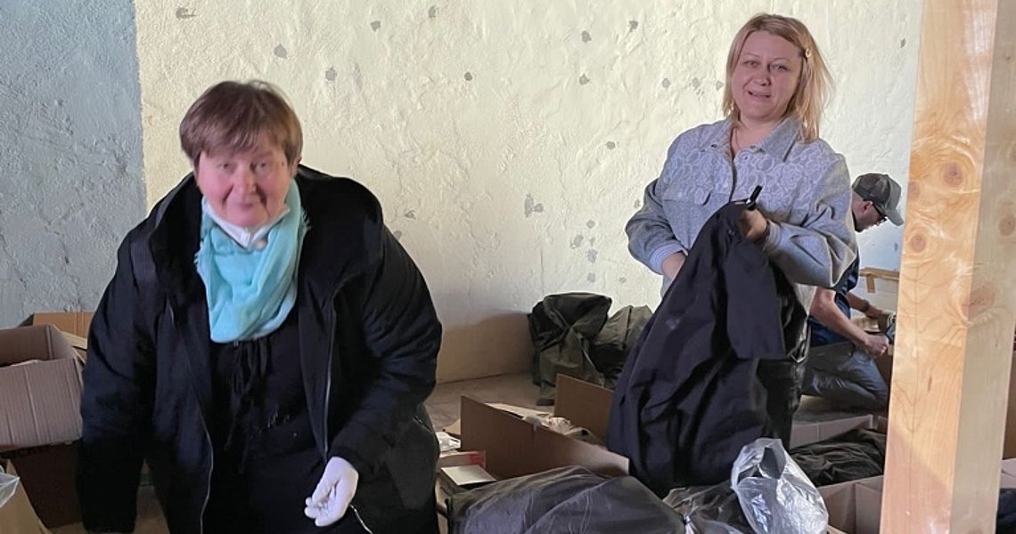 Geflüchtete Frauen aus der Ukraine helfen beim Packen und Beschriften der Kisten