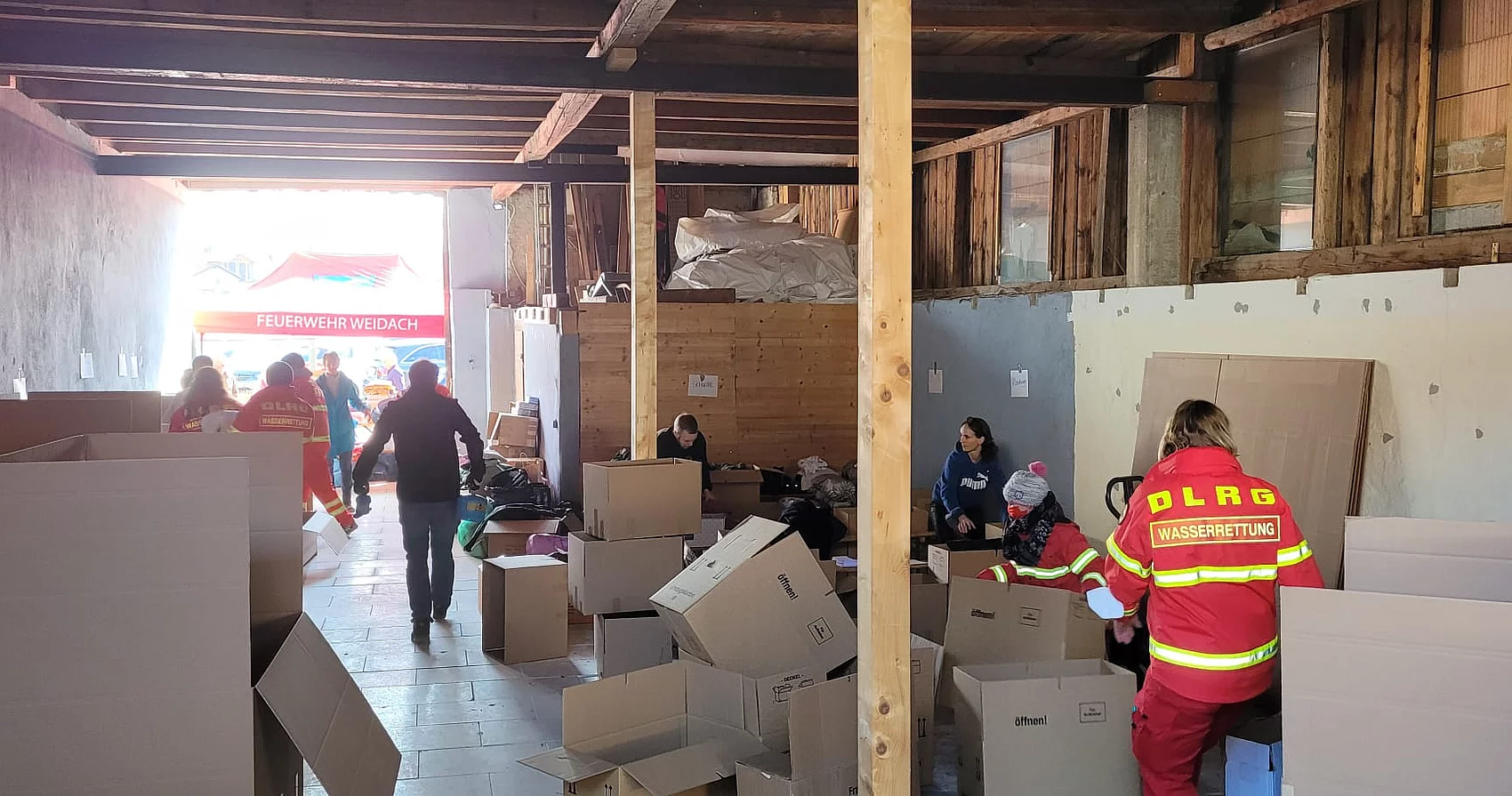 Helfende im Lager beim Packen der Kisten