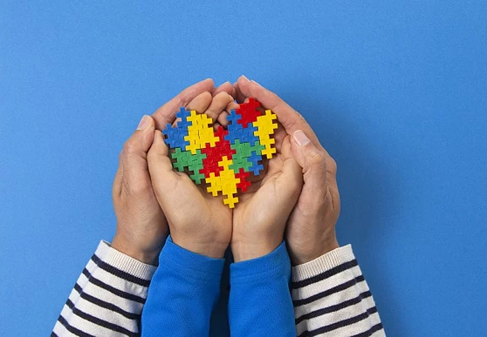 Symbolbild Erwachsenenhände halten Kinderhände mit Puzzelsteinen