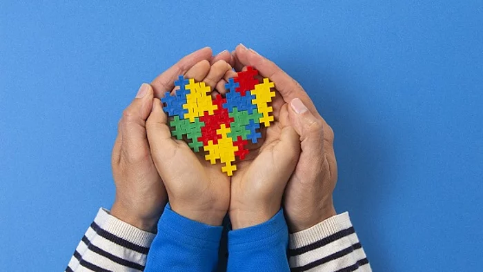 Symbolbild Erwachsenenhände halten Kinderhände mit Puzzelsteinen